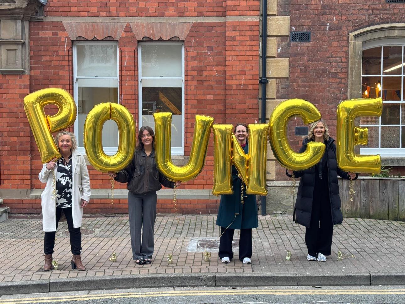 Prime Mix team outisde The Kiln in Worcester holding balloon letters spelling out Pounce